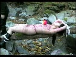 Auf einem Felsen liegend wird die hörige Schlampe mit heißem Wachs zum Wimmern gebracht