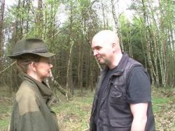 Ein Mann nagelt im Wald eine rasierte Spalte